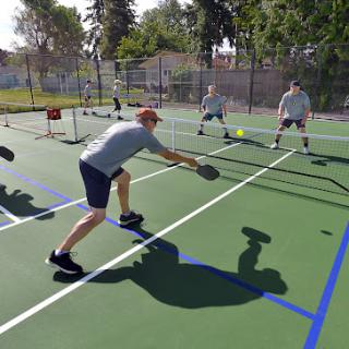 Players engaging in a lively game of pickleball on an outdoor court.