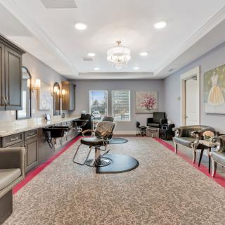 A modern salon interior with a waiting area and hair styling stations.