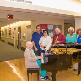A joyful gathering around the piano, where friends share music and laughter.
