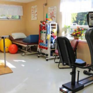 A well-equipped physical therapy room with exercise machines and therapy tools.