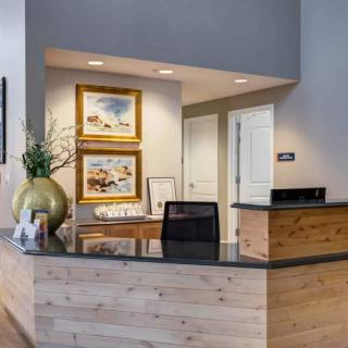 A modern reception area with a wooden desk and decorative artwork on the walls.
