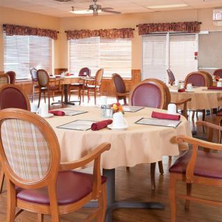 An empty dining room with neatly arranged tables and chairs, ready for guests.