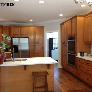 A modern kitchen featuring wooden cabinets and an island with bar stool seating.