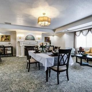 A beautifully decorated dining room with a set table and elegant lighting.