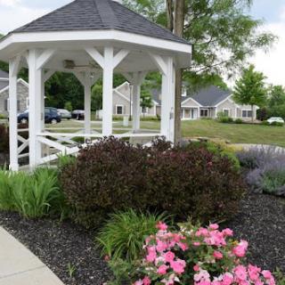 A beautiful gazebo surrounded by colorful flowers and well-maintained landscaping.