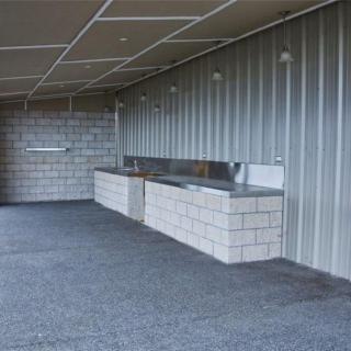 Outdoor kitchen area with concrete counters and metal siding.