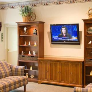 A cozy living room with wooden furniture and a mounted TV.