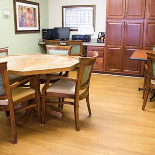A small meeting room with a round conference table, chairs, and office equipment.