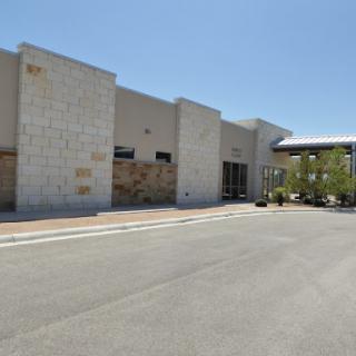 A modern commercial building with a clear blue sky above.