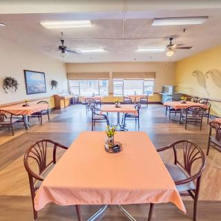 An empty dining room with neatly arranged tables and chairs, featuring a warm and inviting decor.