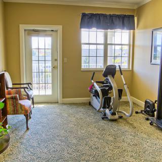 A cozy home gym with an exercise bike and seating area.