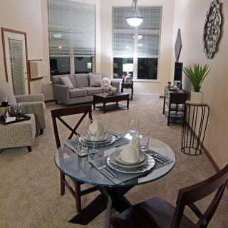 A cozy and modern living room with an adjoining dining area, featuring elegant furniture and tasteful decor.