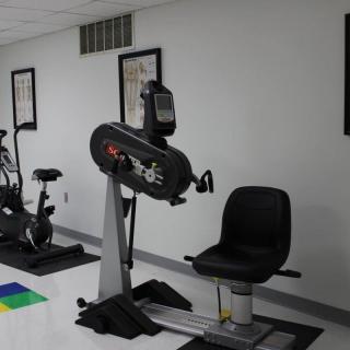 A fitness room featuring a recumbent stationary bike and other exercise equipment.