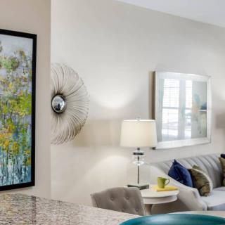A modern living room with stylish decor, featuring a comfortable sofa, artwork on the wall, and elegant lighting.