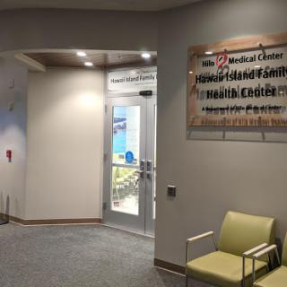 Entrance to a medical facility featuring a waiting area and informational signage.