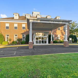 The image shows the front entrance of a brick building with a canopy.