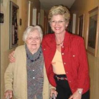 Two women standing together in a hallway, showing companionship and support.