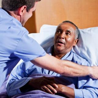 A nurse providing care to a patient in a hospital bed.