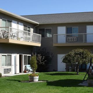 A two-story apartment complex with balconies and a well-maintained lawn area.