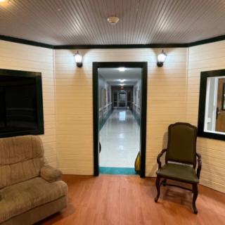 A cozy interior space featuring comfortable seating, warm lighting, and a long hallway.