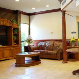 A cozy living room with a leather sofa, wooden coffee table, and cabinets.