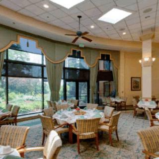 A stylish dining area with natural light, featuring elegantly set tables and comfortable seating.
