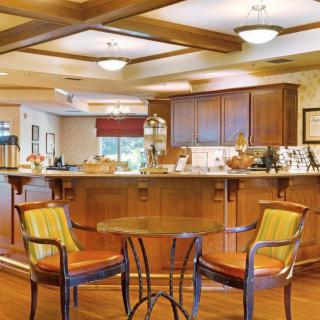 A cozy kitchen and dining area featuring wooden cabinetry, a coffee bar, and seating.