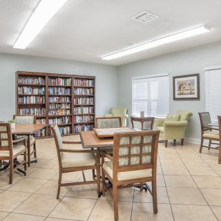 A bright and inviting reading room with bookshelves, tables, and chairs.