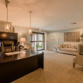 A modern, warmly-lit office reception area with a desk and comfortable seating.