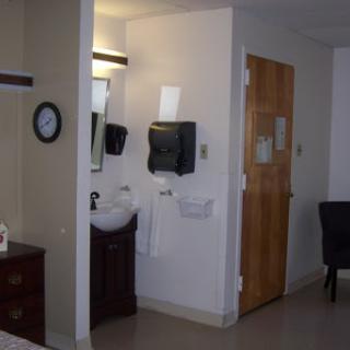 A view of a hotel room featuring a bathroom area with a sink and door.