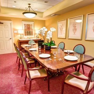 A beautifully set dining room with a long table, chairs, and decorative artwork on the walls.