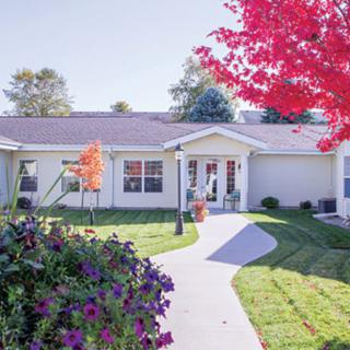 A charming house with a well-maintained garden and colorful autumn foliage.