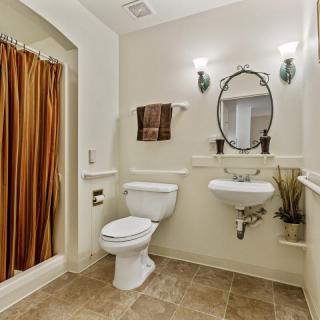 A clean and well-decorated bathroom with a toilet, sink, and shower.