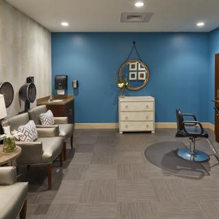 A modern salon interior featuring a waiting area and a hairdressing station.