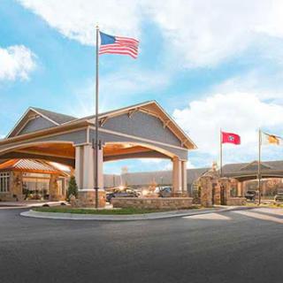 A welcoming hotel entrance featuring multiple flags and modern architecture.
