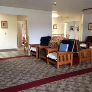 A cozy living room with wooden furniture and carpeted floor.