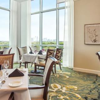 An elegant restaurant dining area with large windows offering a scenic view.