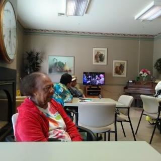 Elderly individuals gathered in a community center, enjoying various activities.