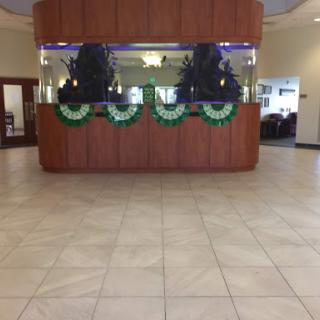 A spacious lobby area featuring a wooden reception desk and decorative elements.