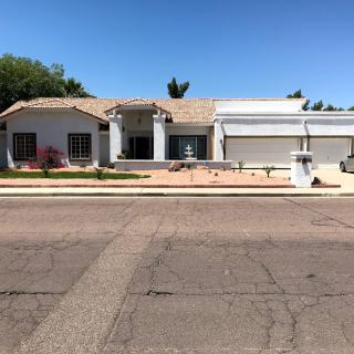 A suburban house with a driveway and garage under a clear blue sky.