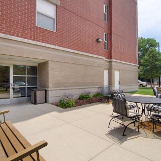 Outdoor patio area with seating and tables next to a brick building.