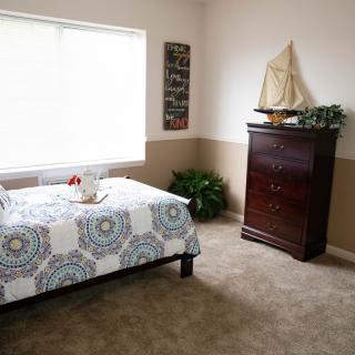 Cozy bedroom with nautical-themed decor and natural lighting.