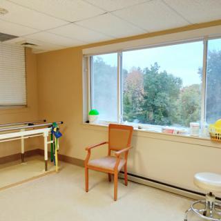 A calming therapy room featuring a large window with a view of nature, designed for patient comfort.