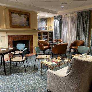 A cozy lounge area featuring comfortable seating, a fireplace, and inviting decor.