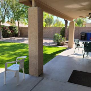 A sunny patio view with a well-maintained lawn.