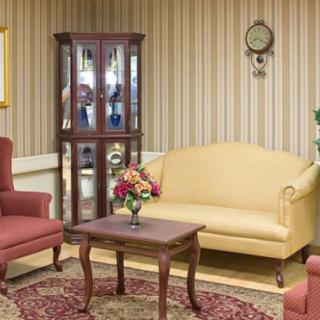 A vintage-style living room featuring a sofa, armchairs, and a coffee table with a floral centerpiece.