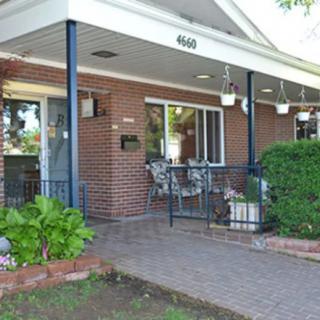 A cozy brick house with a covered porch and outdoor seating.