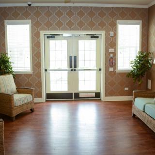 A cozy waiting area with sofas and plants near double doors.