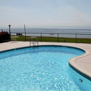 A swimming pool with an ocean view on a clear day.