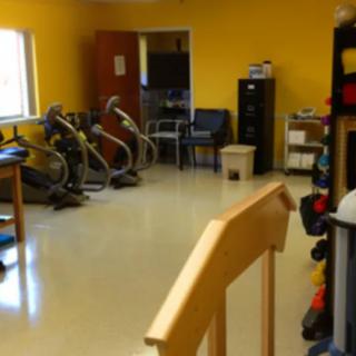 A rehabilitation room equipped with exercise machines and a variety of therapy tools.